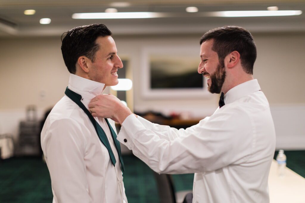 Alex’s groomsman helping him get ready for the wedding