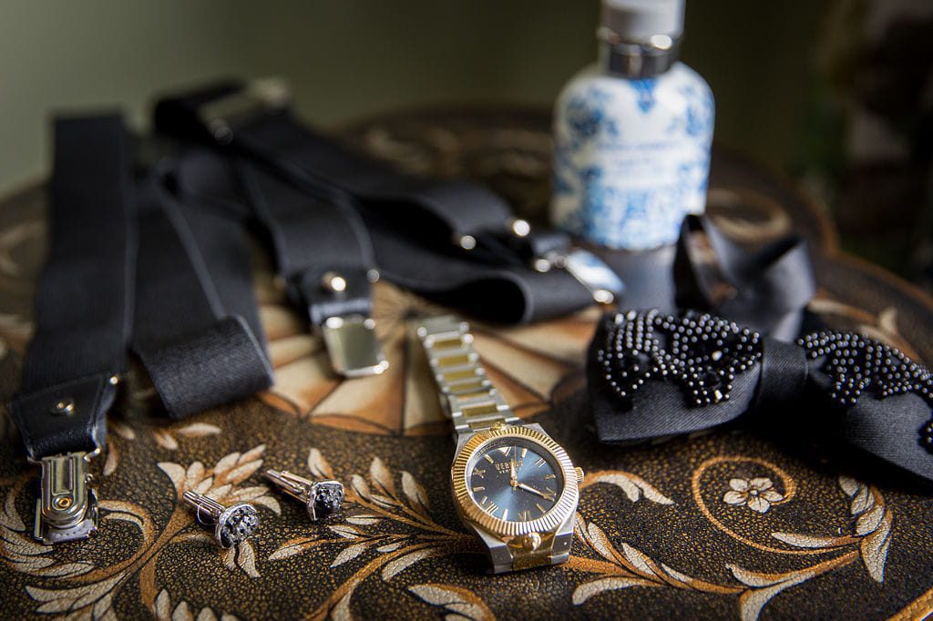 Alex’s black bow tie, suspenders, cufflinks, watch, and wedding-day fragrance