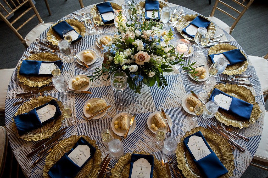Overhead view of a blue-and-gold mountain wedding tablescape