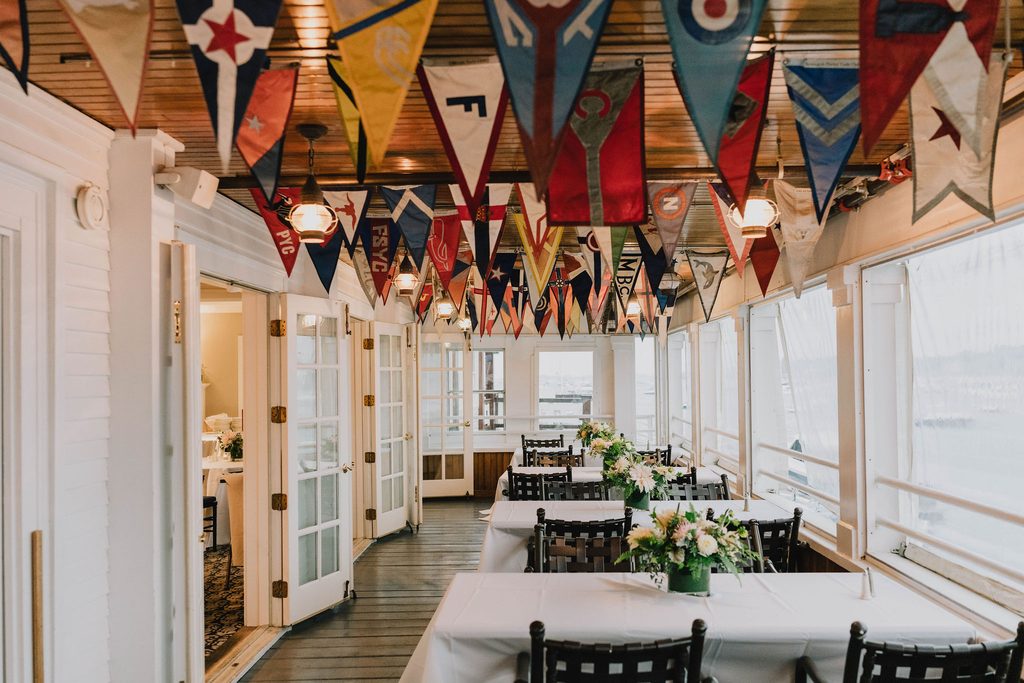 Waterfront wedding reception tables inside the Boston Yacht Club