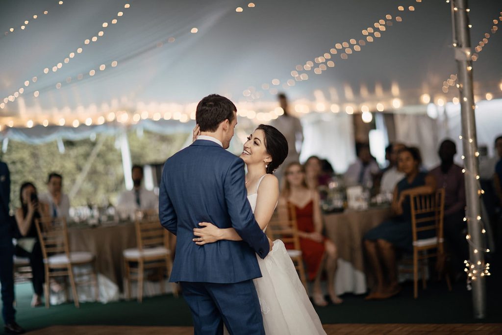 Caroline and Arthur sharing their first dance beneath reception string lights
