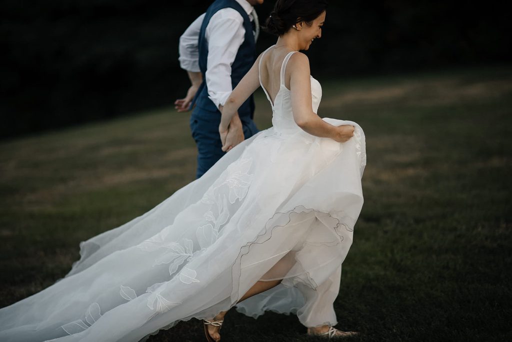 Caroline and Arthur running together across the lawn at Dexter’s Inn