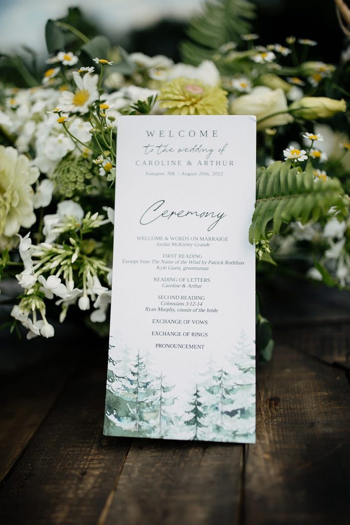 Woodland-inspired ceremony program with white and green flowers