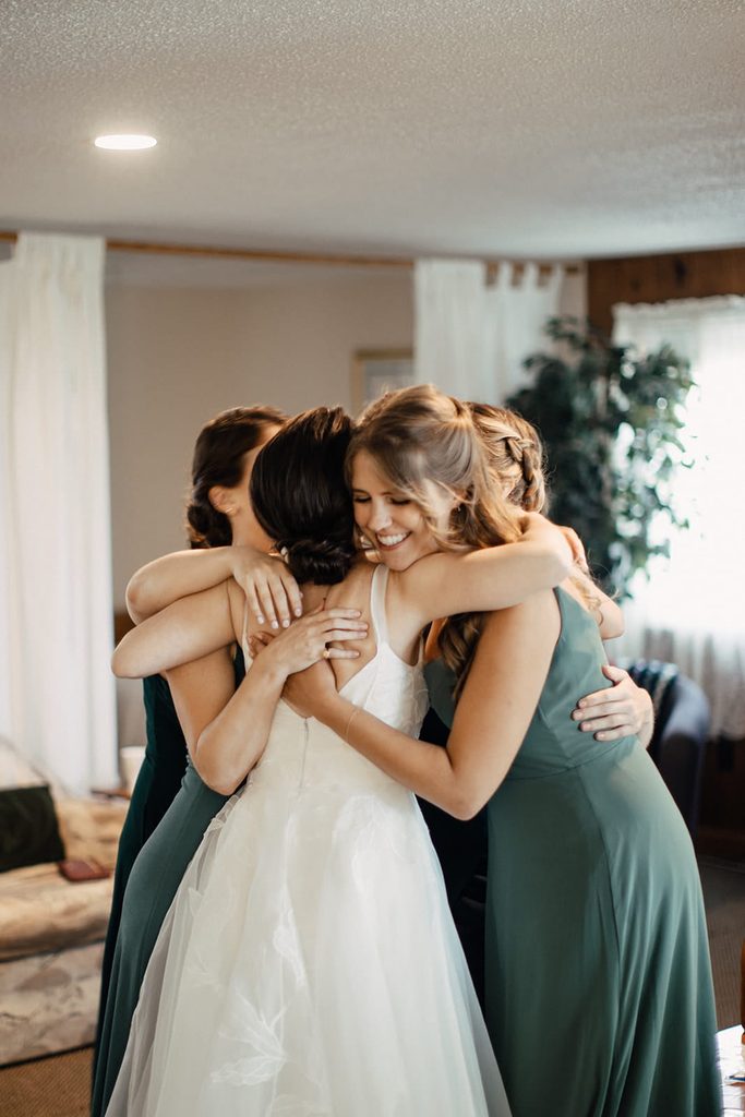 Caroline sharing a group hug with her bridesmaids while getting ready