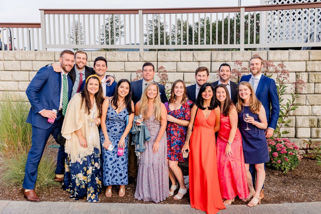 Group of guests in colorful cocktail attire at a New Hampshire wedding