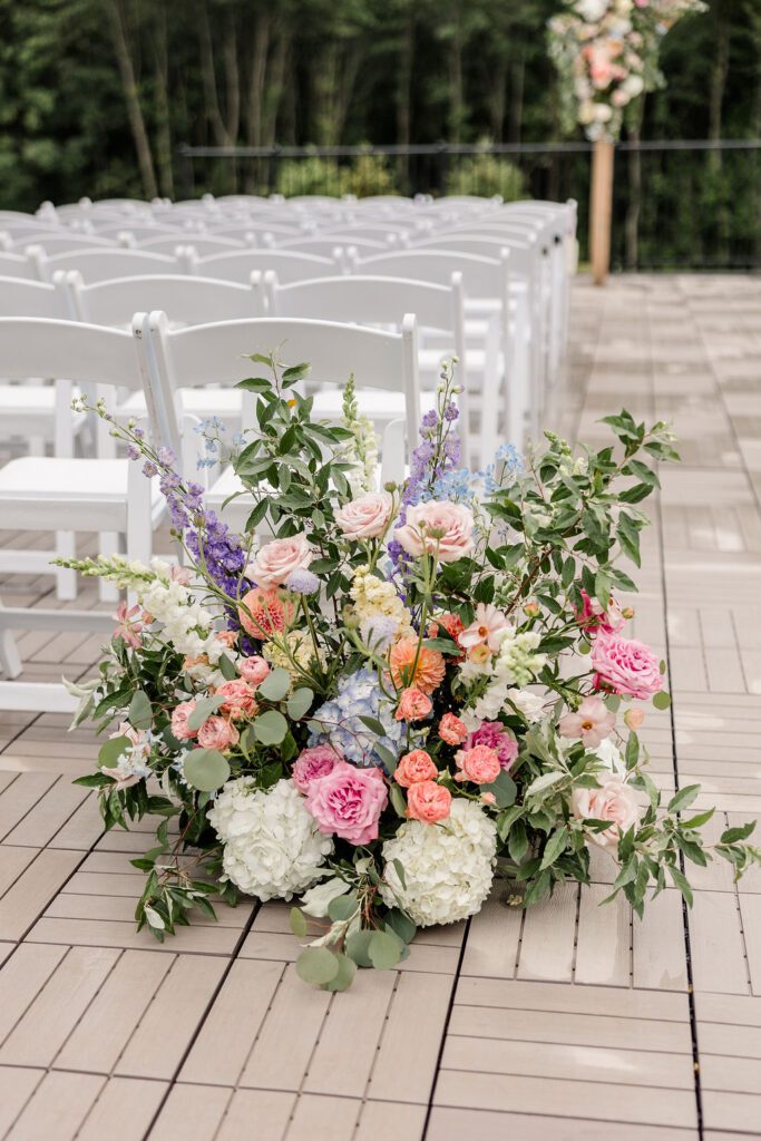 Colorful grounded aisle flowers in pink, apricot and lilac at Hyla Brook Estate in Derry, New Hampshire