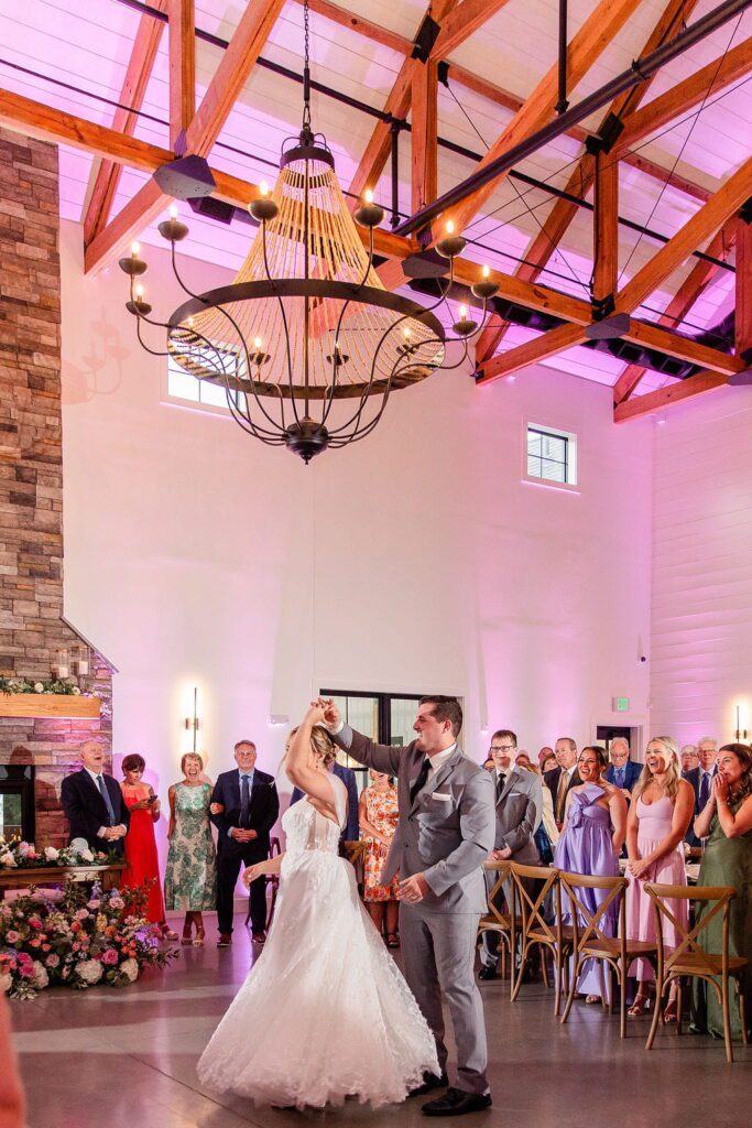 Emily and Cory twirling during their first dance at Hyla Brook Estate
