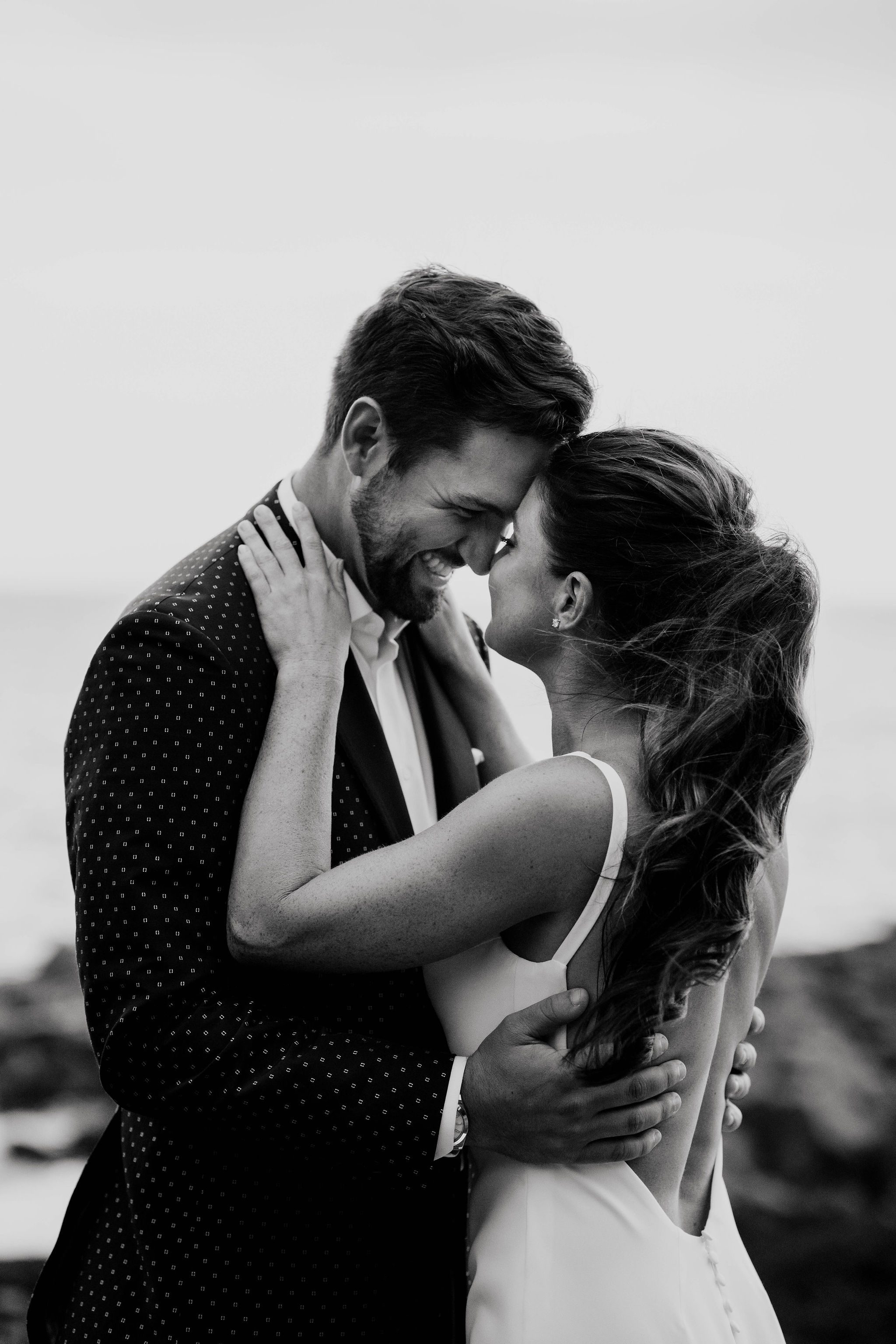 Erin and Rob embracing during their waterfront wedding portraits in Marblehead