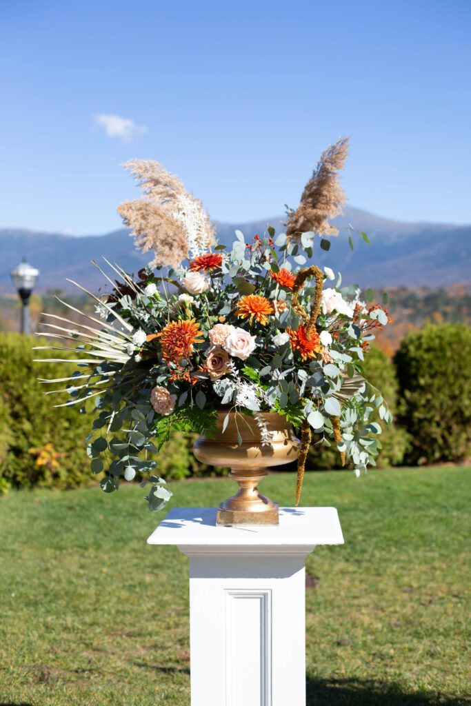 Orange and blush ceremony flowers overlooking the White Mountains