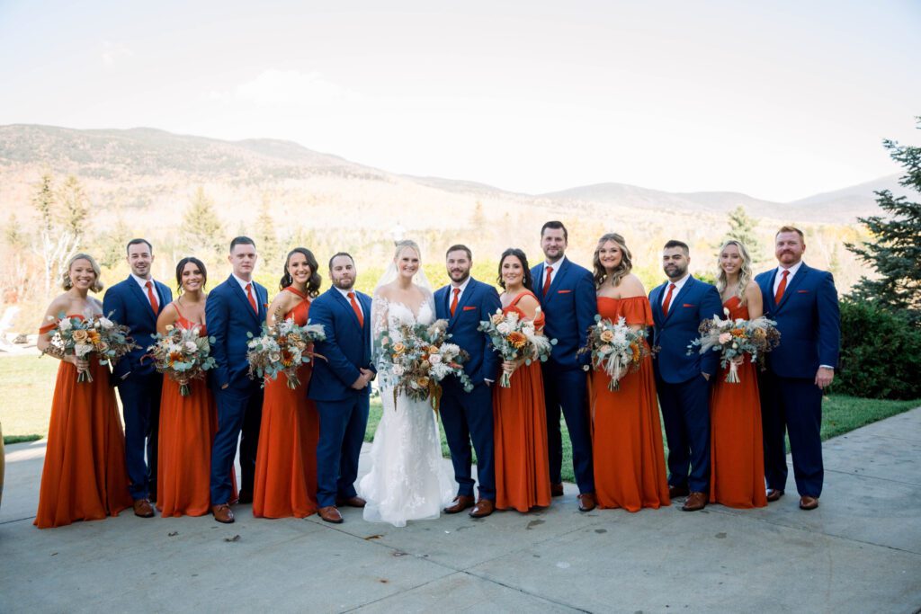 Nicole and Tom’s wedding party in burnt orange dresses and navy suits