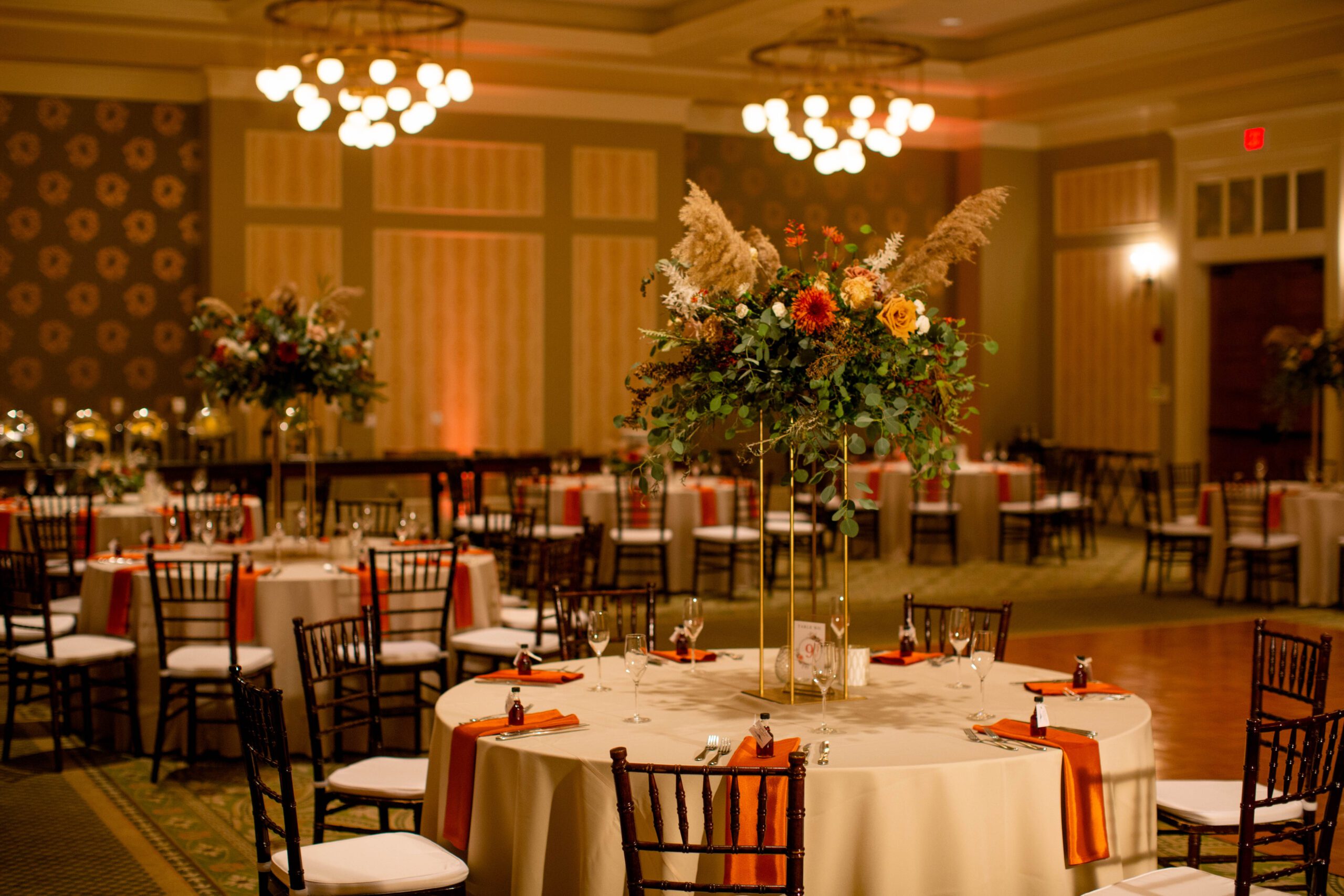 Fall wedding reception at Omni Mount Washington with orange linens and tall floral centerpieces