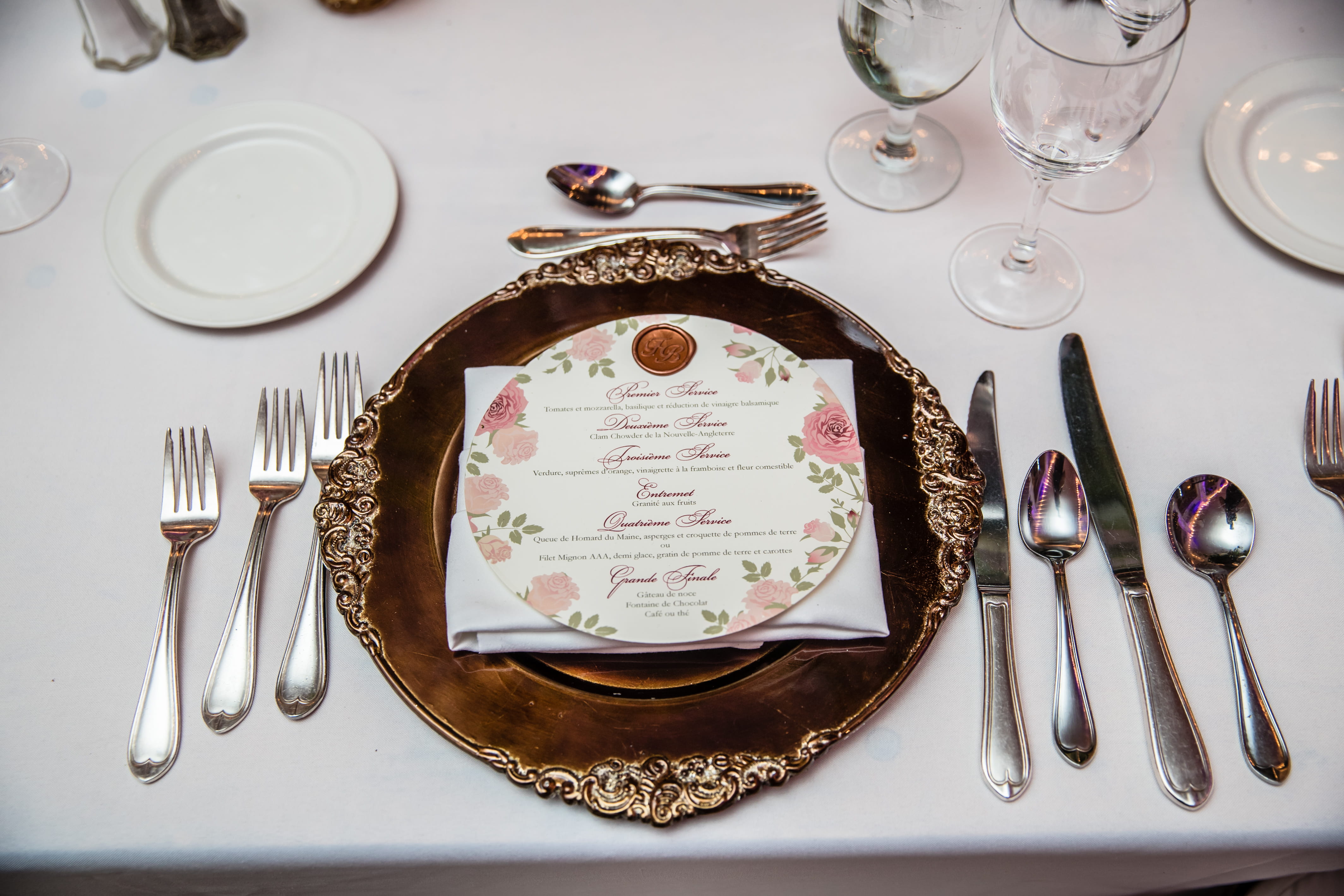 French wedding menu displayed on an ornate gold charger