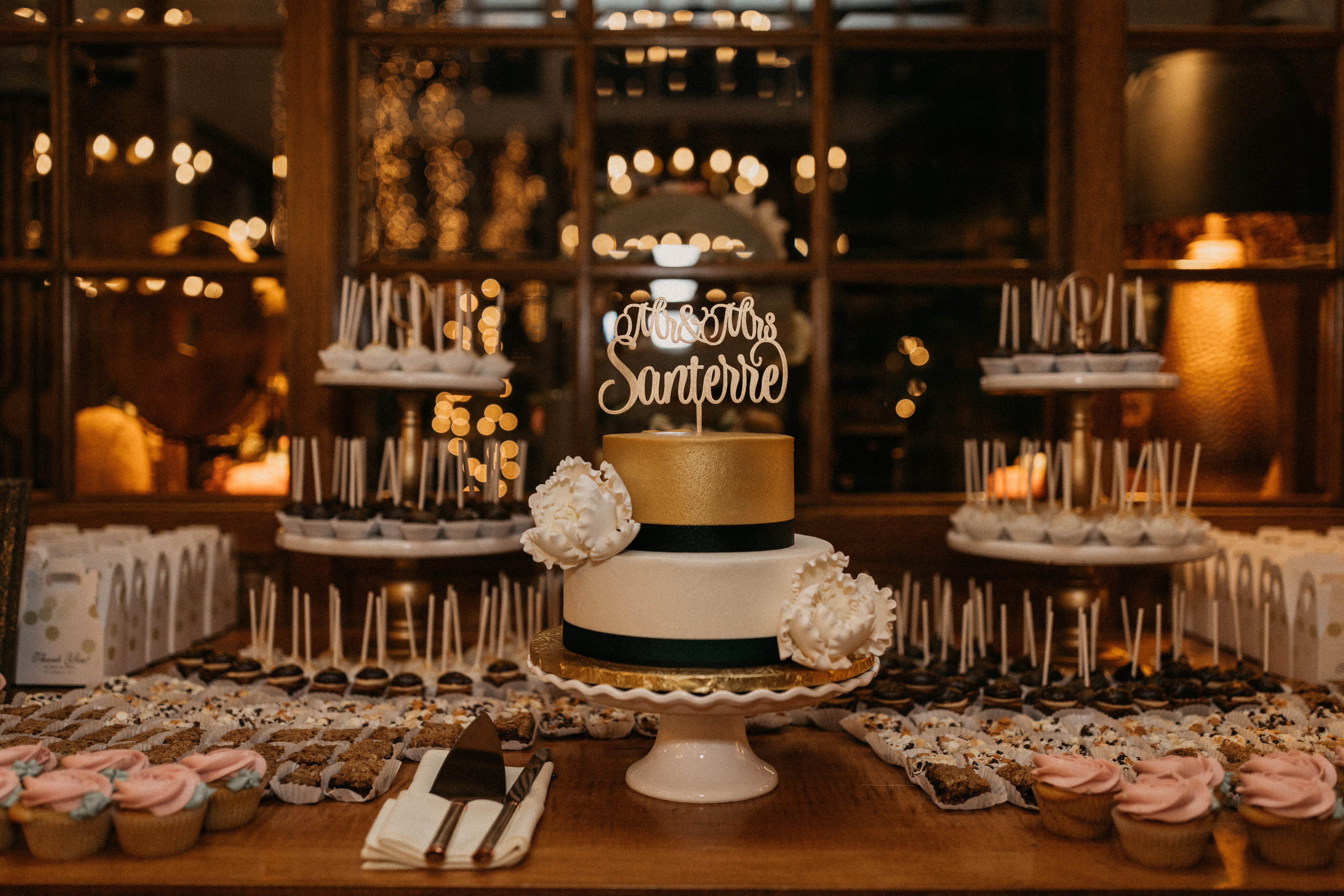 Gold and white wedding cake with desserts at Bedford Village Inn