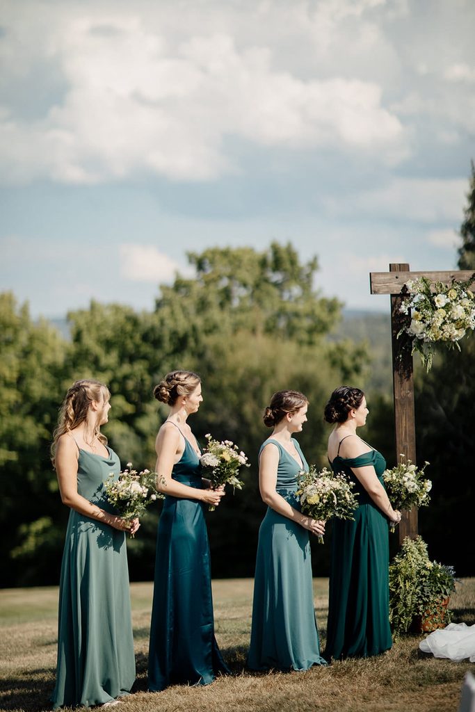 Bridesmaids in green dresses at Caroline and Arthur’s outdoor ceremony