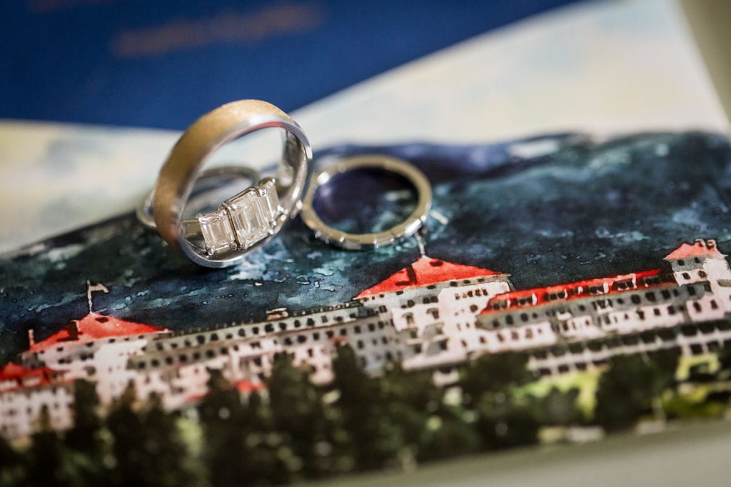 Katie and Alex’s wedding rings on an illustration of the Omni Mount Washington