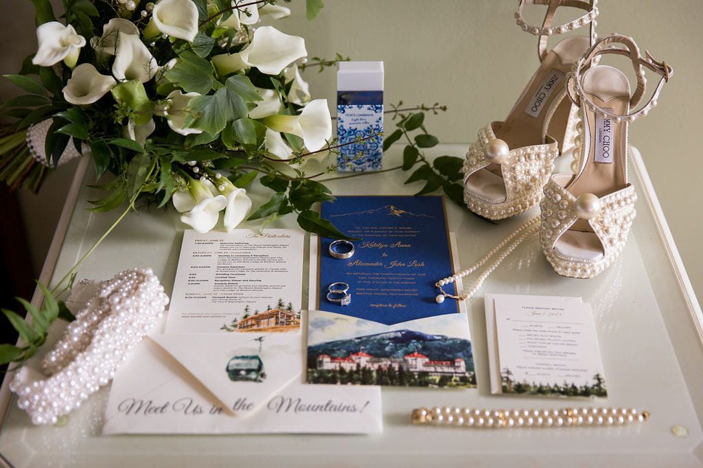 Katie’s pearl wedding shoes, bouquet, jewelry, and mountain-themed stationery