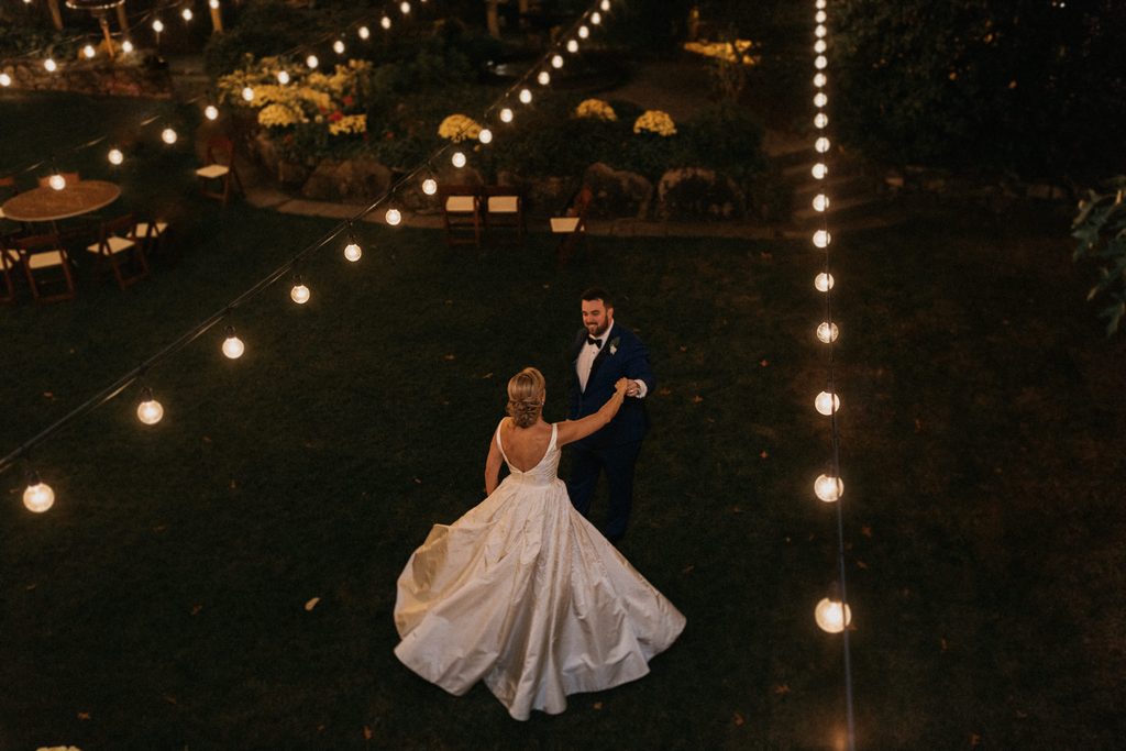 Kerry and Jake dancing beneath string lights at Bedford Village Inn
