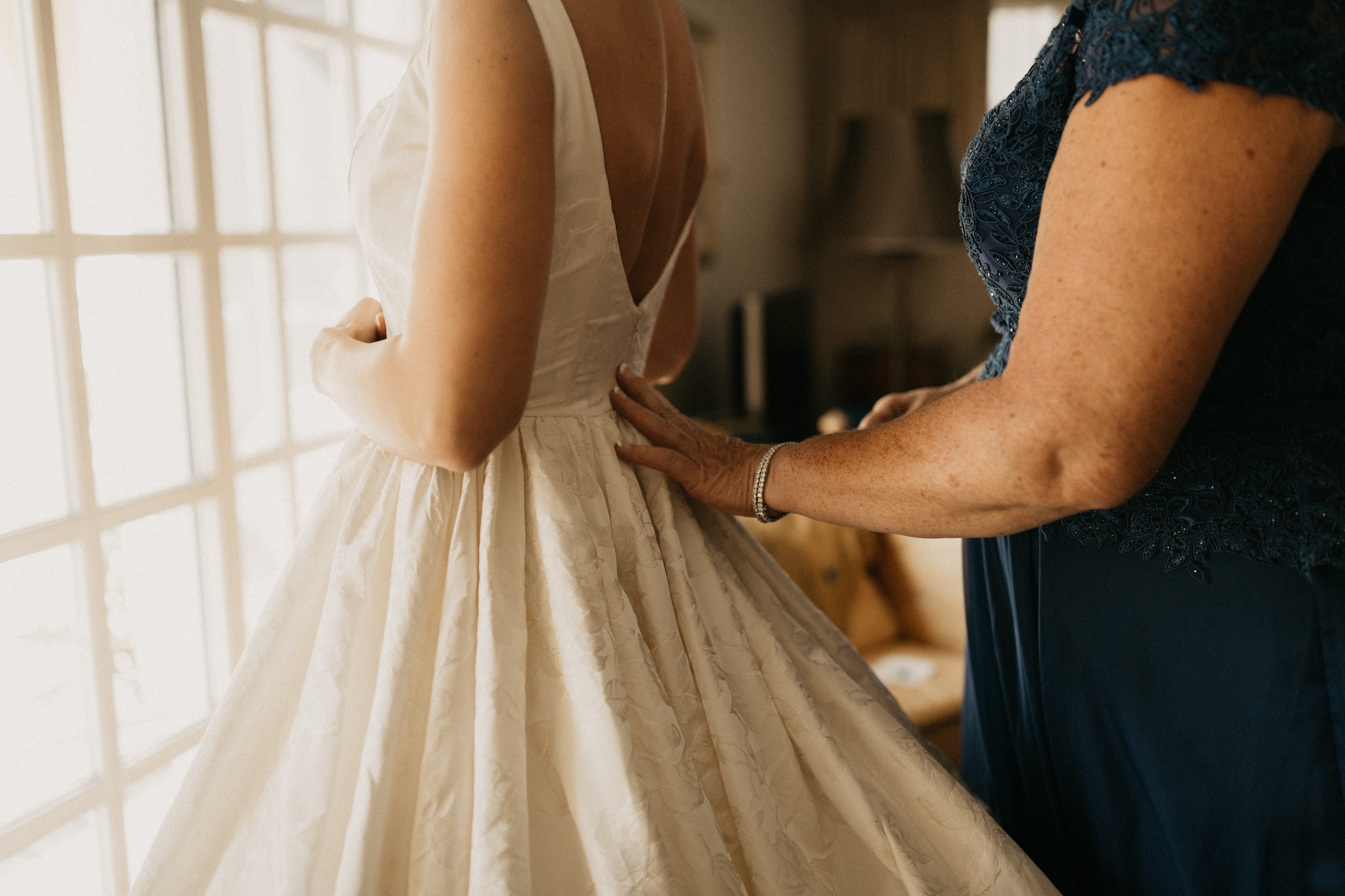 Kerry’s mother helping her into her wedding dress