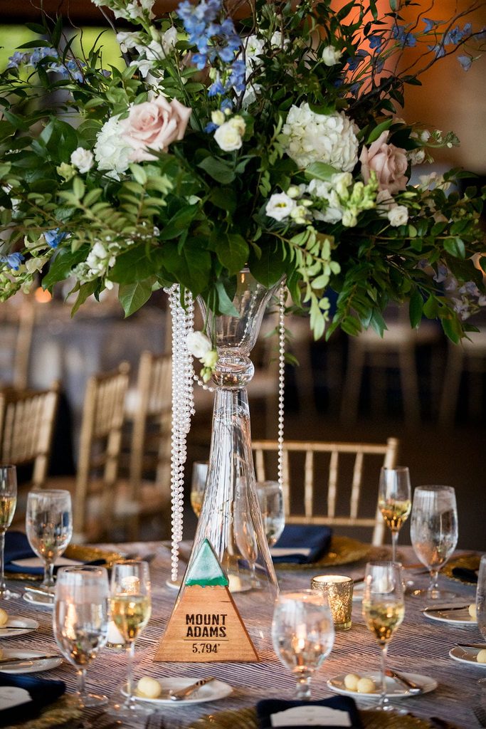 Tall blue and white floral centerpiece with a Mount Adams table marker