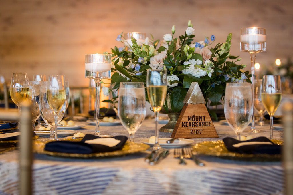 Mount Kearsarge table marker with blue flowers, greenery, and floating candles