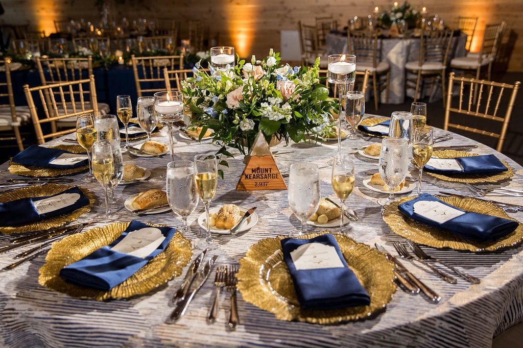 Mount Kearsarge wedding table with blue napkins and gold chargers
