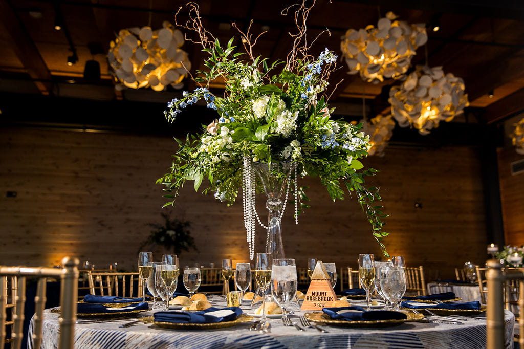 Mount Kearsarge table marker with blue flowers, greenery, and floating candles