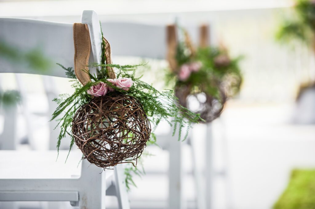 Woven greenery and pink rose decoration attached to a ceremony chair at Omni Mount Washington Resort in Bretton Woods, New Hampshire