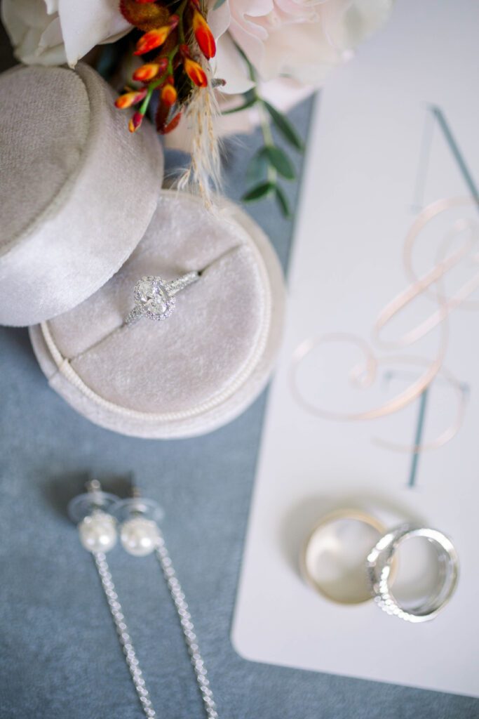 Nicole’s engagement ring displayed with pearl earrings and wedding bands