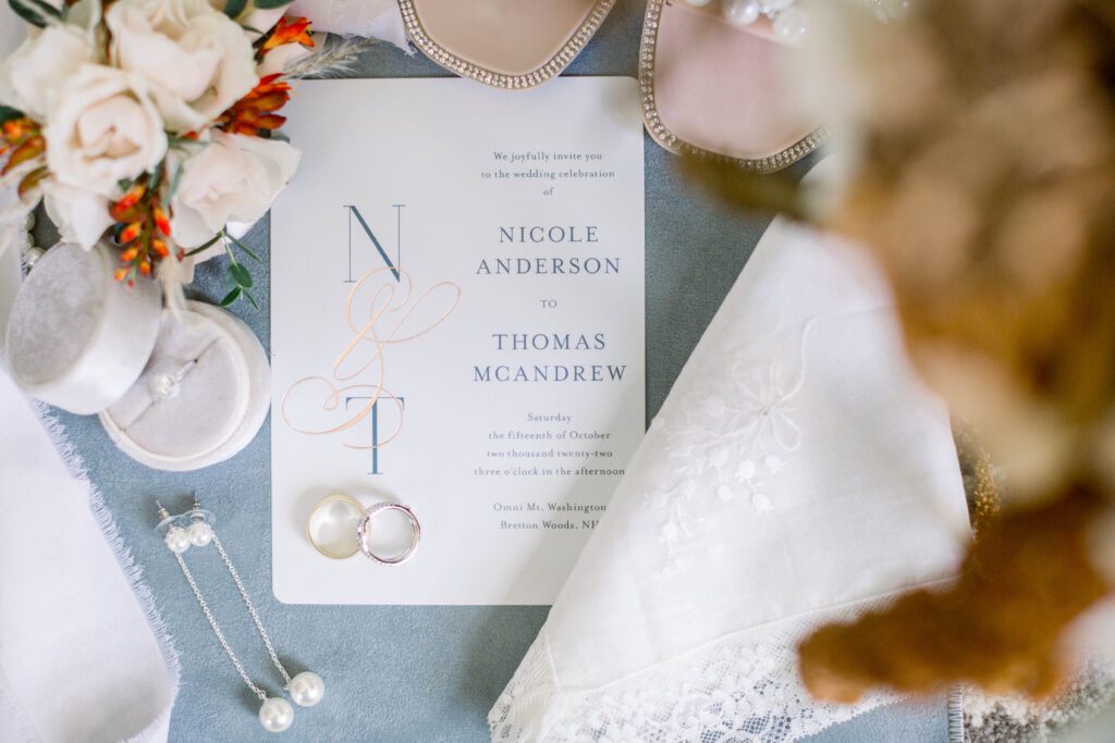 Nicole and Tom’s wedding invitation with rings, flowers and bridal accessories