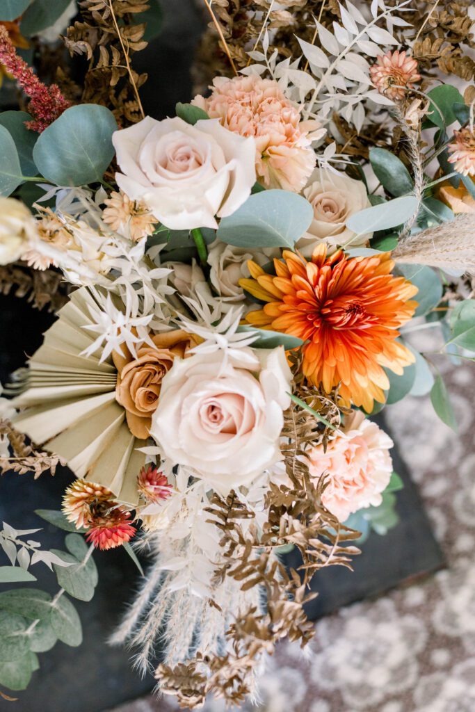 Orange and blush fall wedding flowers with eucalyptus and dried foliage