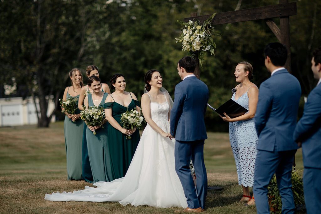 Outdoor wedding ceremony beneath a wooden arbor at Dexter’s Inn in Sunapee, New Hampshire