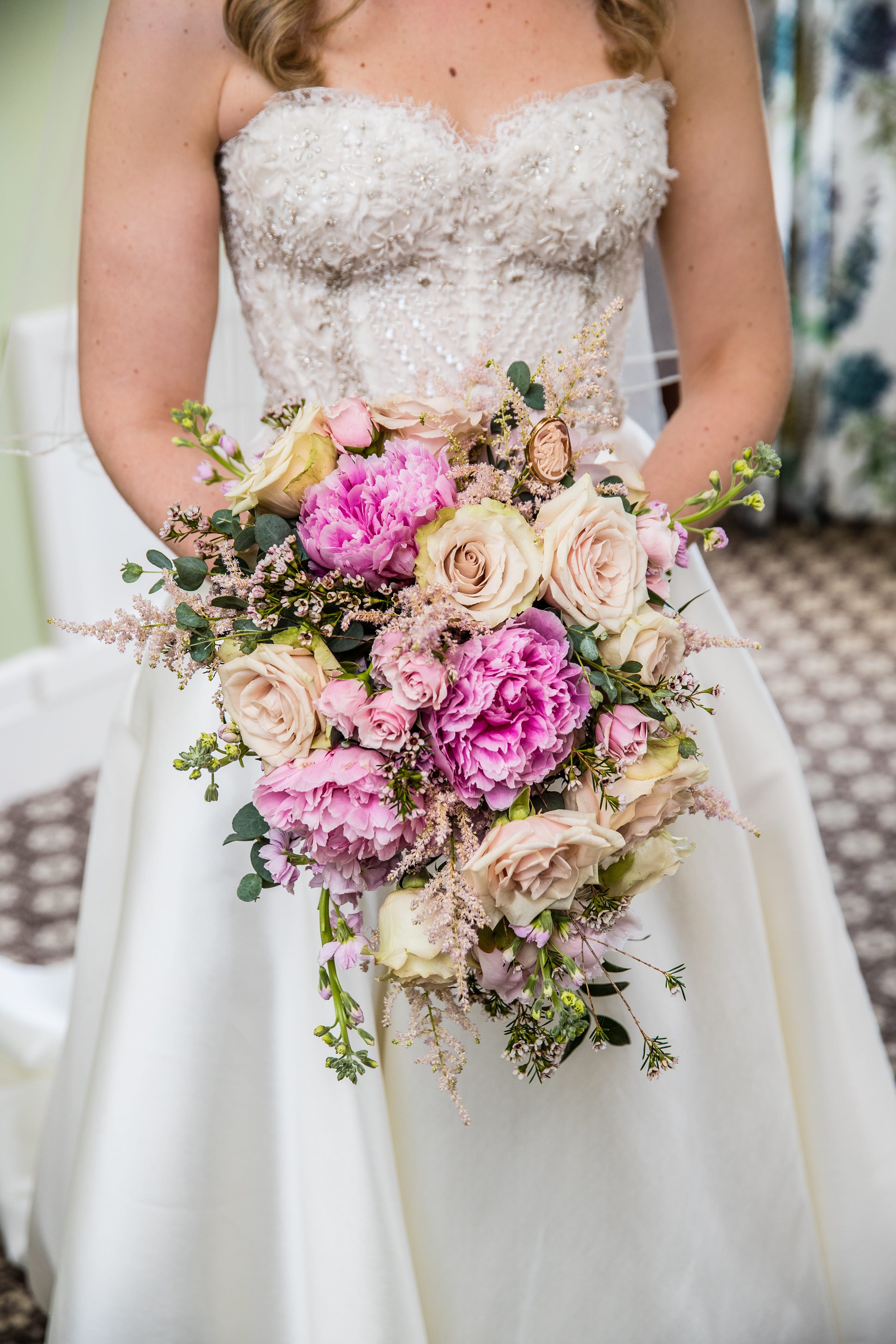 Francesca holding a cascading bouquet of dusty pink peonies, roses and greenery