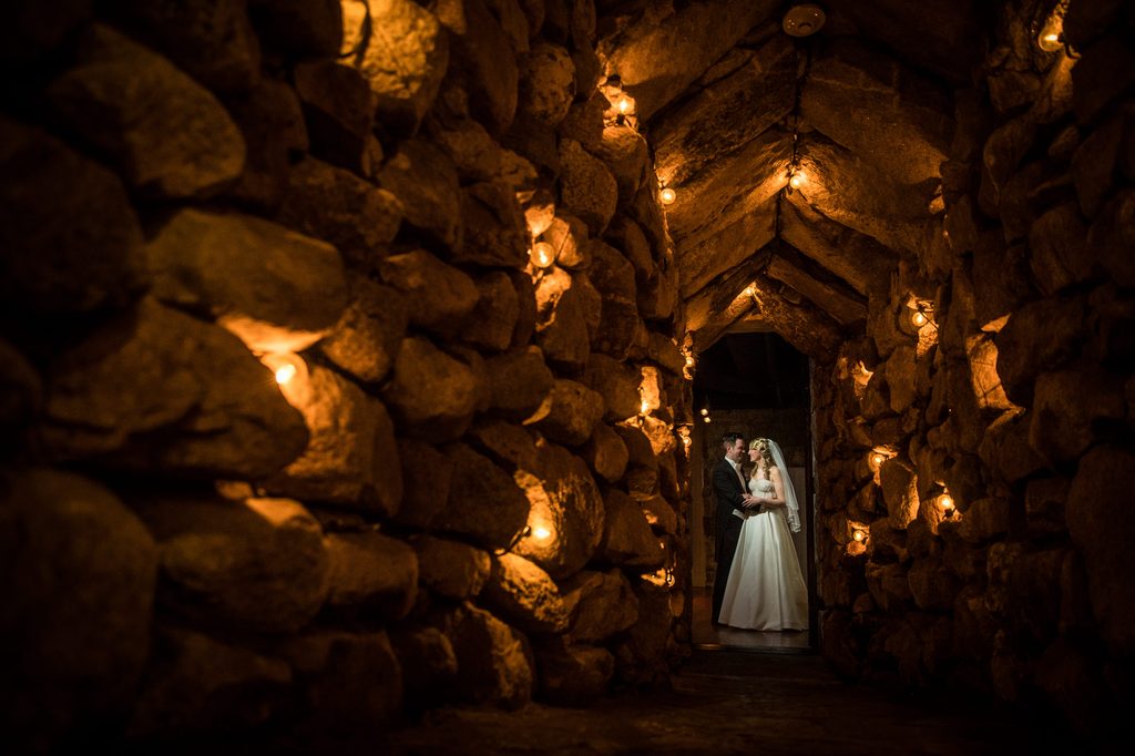 Francesca and Bernard in a candlelit stone passageway at the Omni Mount Washington