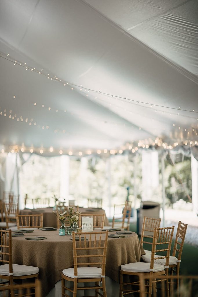 Rustic wedding reception table beneath string lights at Dexter’s Inn