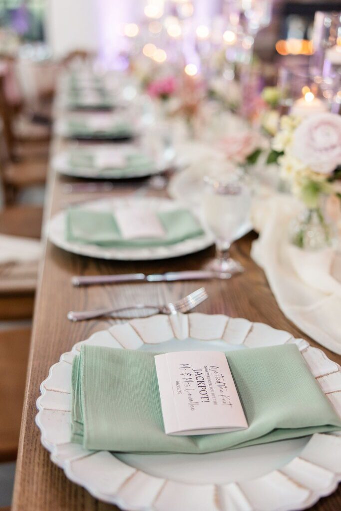 Scratch ticket wedding place card on a sage green napkin at Hyla Brook Estate