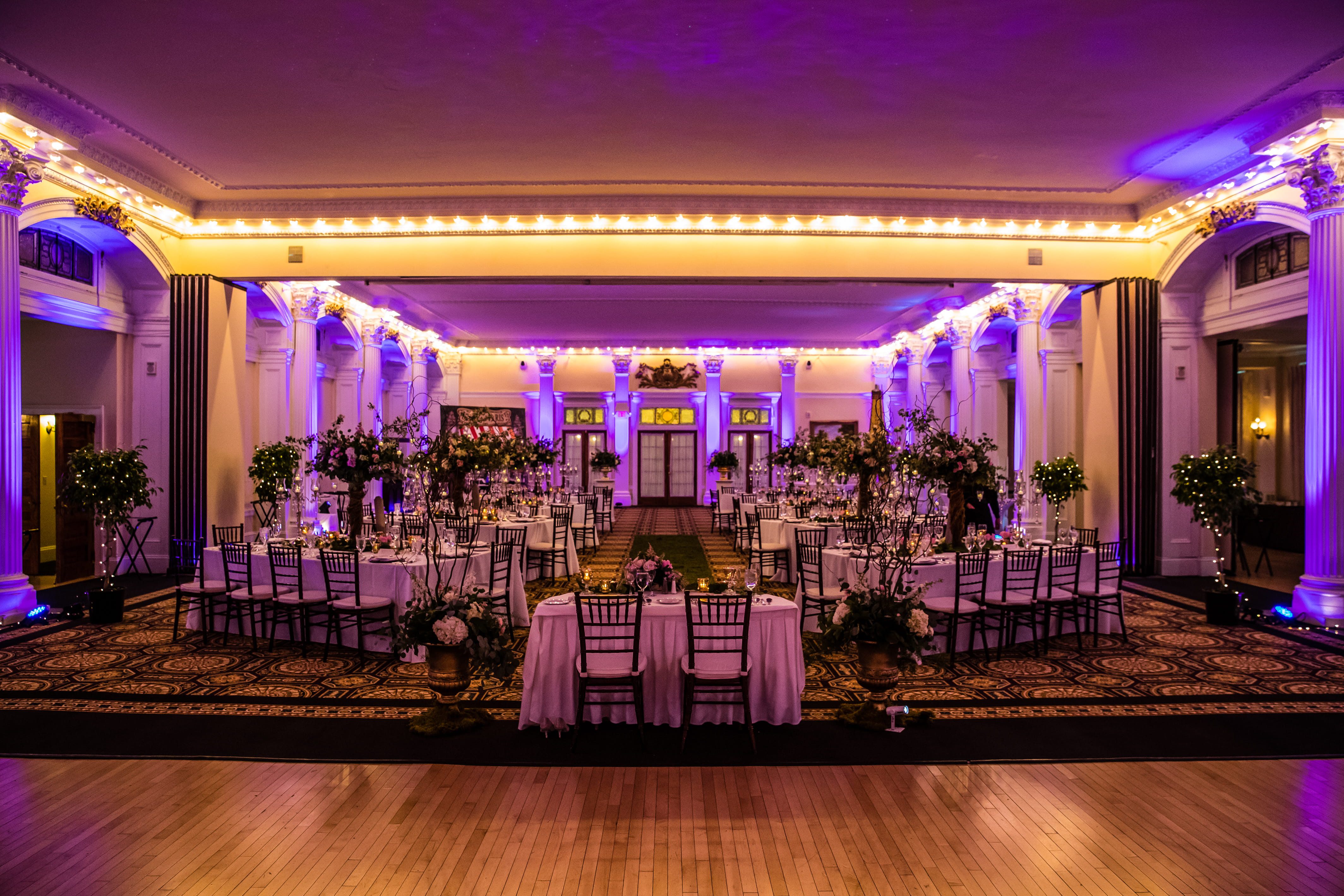 Romantic wedding reception with purple uplighting at the Omni Mount Washington Resort